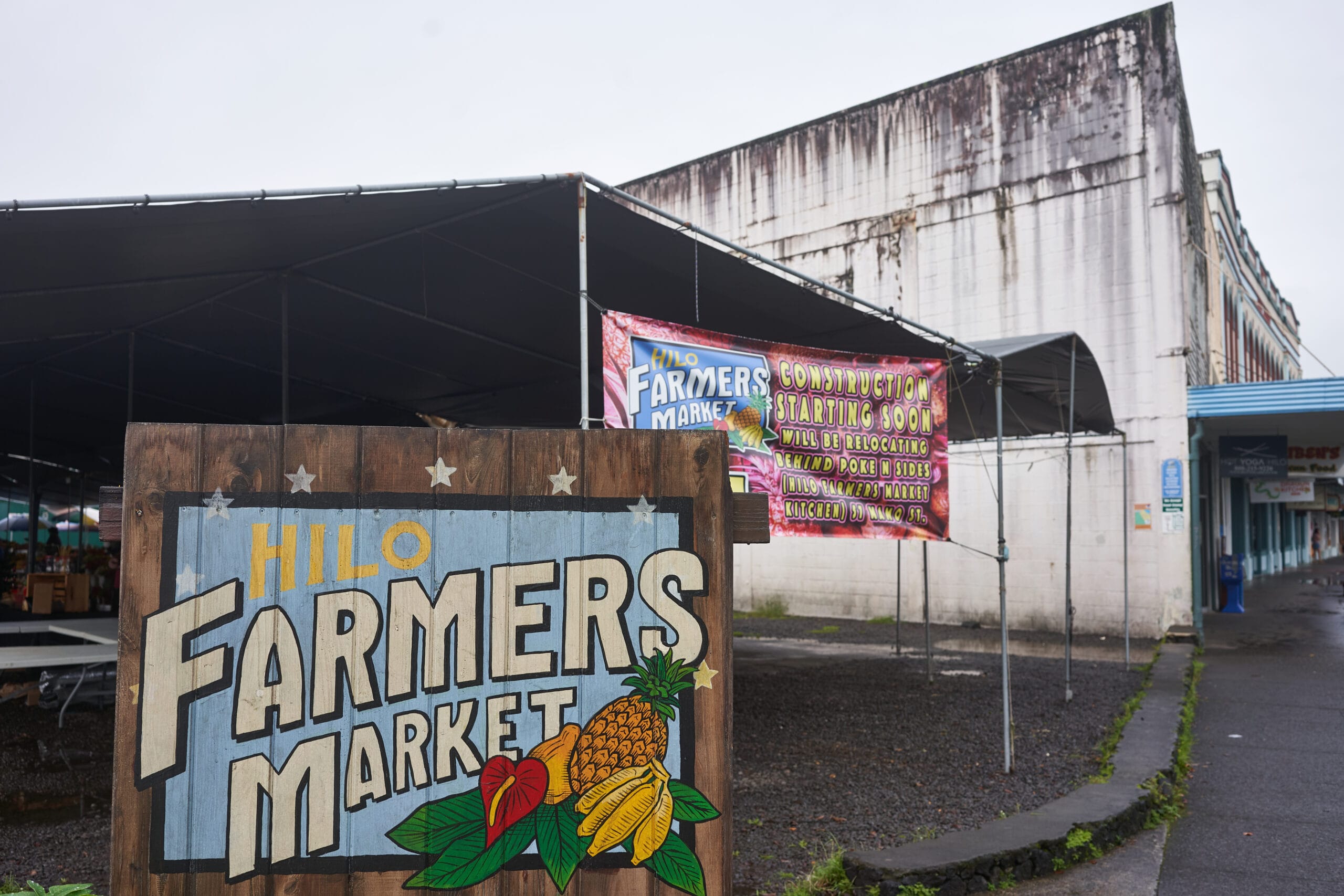 hilo farmers market sign with tropical fruits
